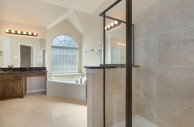 a spacious bathroom with a tub sink and mirror