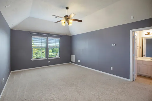 a view of an empty room with a ceiling fan
