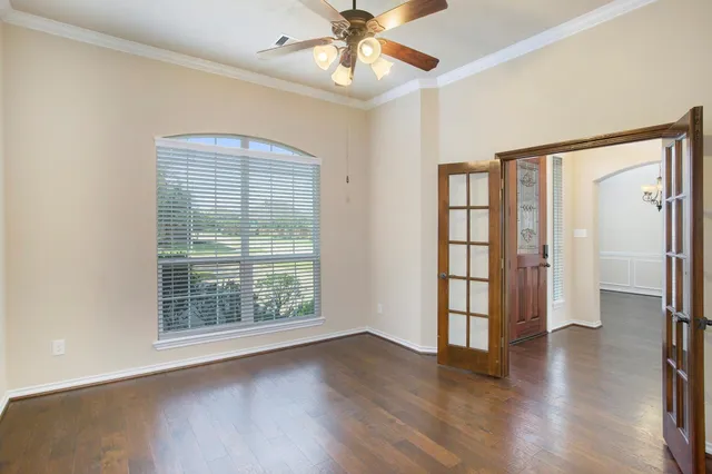 a view of an empty room with a window and wooden floor