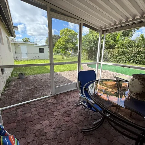 a view of a porch with furniture and a yard