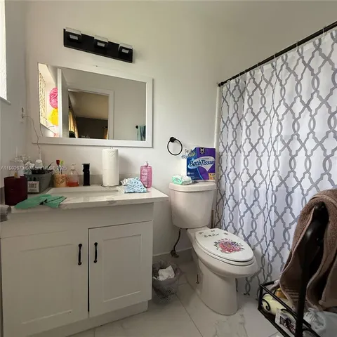 a bathroom with a granite countertop toilet sink and mirror