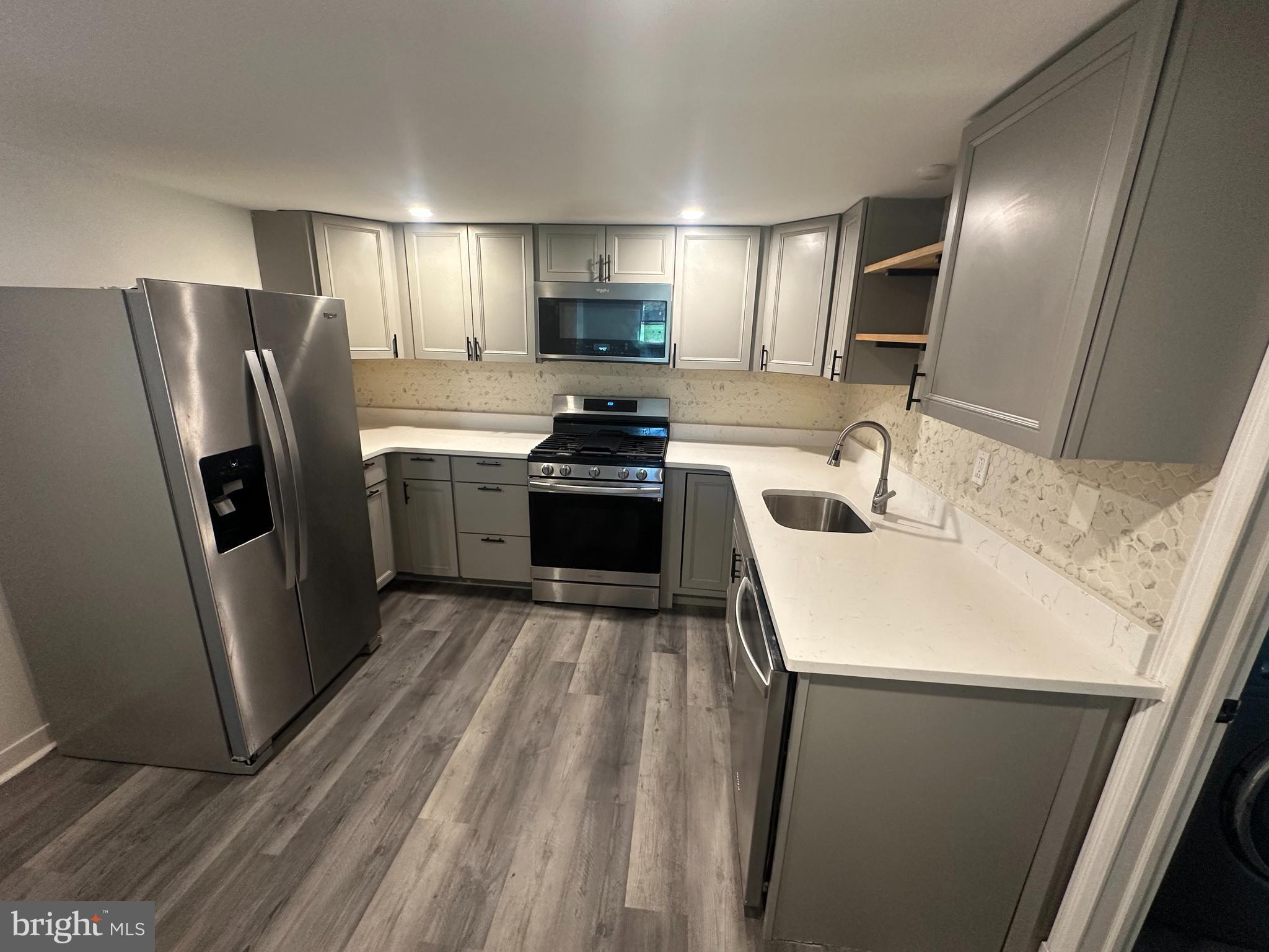 1411 Zebley Road, Unit A Garnet Valley, PA 19060 - Photo 8 of 17 a kitchen with stainless steel appliances a refrigerator a sink a stove a microwave and island
