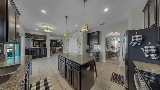 a kitchen with stainless steel appliances kitchen island granite countertop a refrigerator and stove top oven