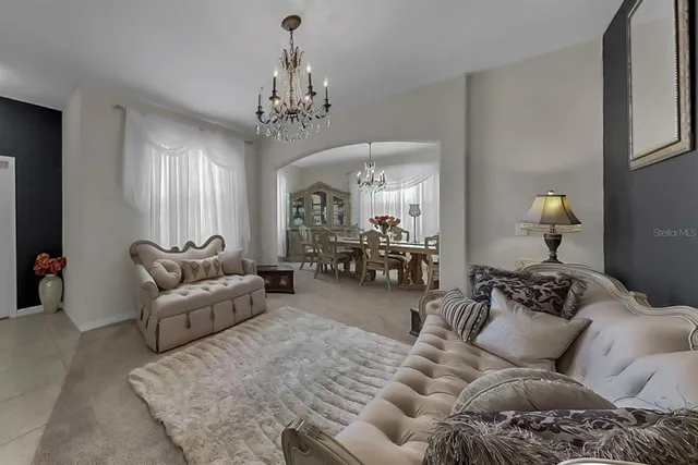 a living room with furniture and a chandelier