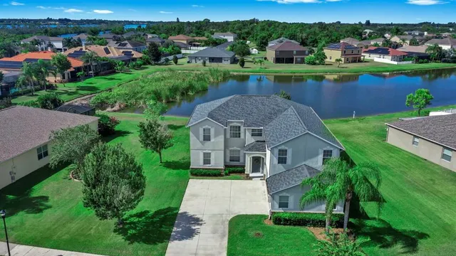 an aerial view of a house with yard and lake view