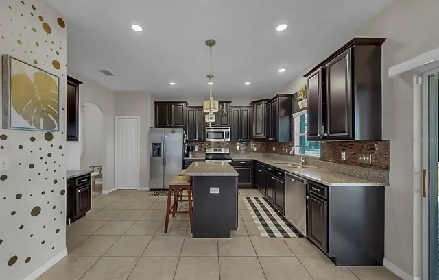 a kitchen with stainless steel appliances granite countertop a stove a sink and a refrigerator