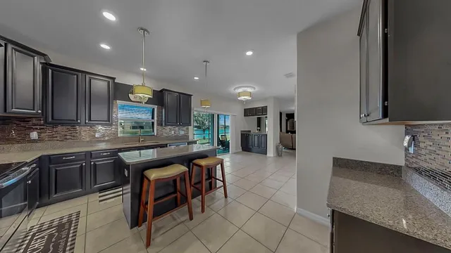 a kitchen with stainless steel appliances granite countertop a sink and a refrigerator