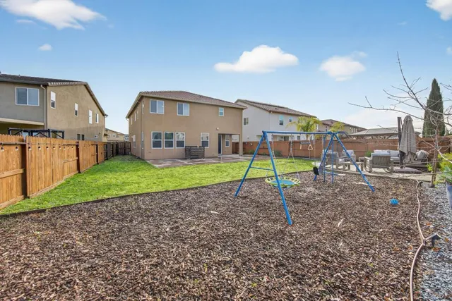 a view of a house with a backyard and a road