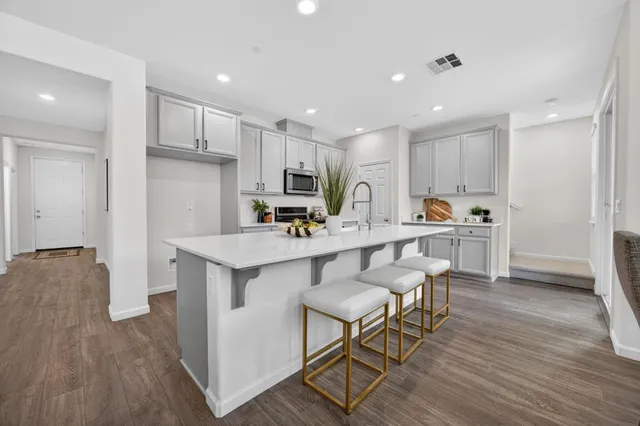 a kitchen with a sink a refrigerator and wooden floor