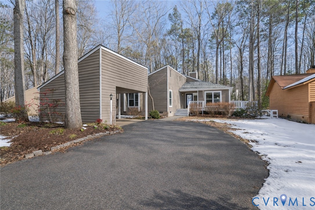 Mid-century home with asphalt driveway and a carpo
