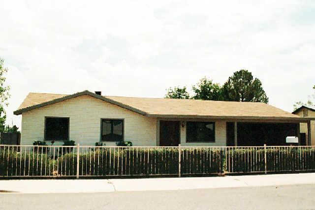4061 East Hearn Road Phoenix, AZ 85032 - Photo 1 of 1 a view of a house with a small yard and wooden fence