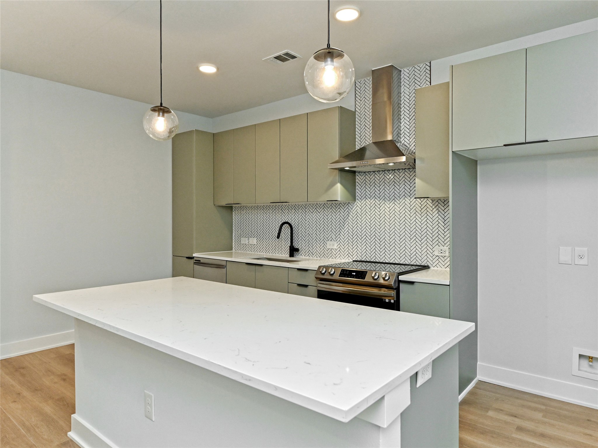 2500 Longview Street, Unit 518 Austin, TX 78705 - Photo 4 of 20 Kitchen with stainless steel electric stove, wall chimney exhaust hood, a sink, gray cabinetry, and light laminate flooring