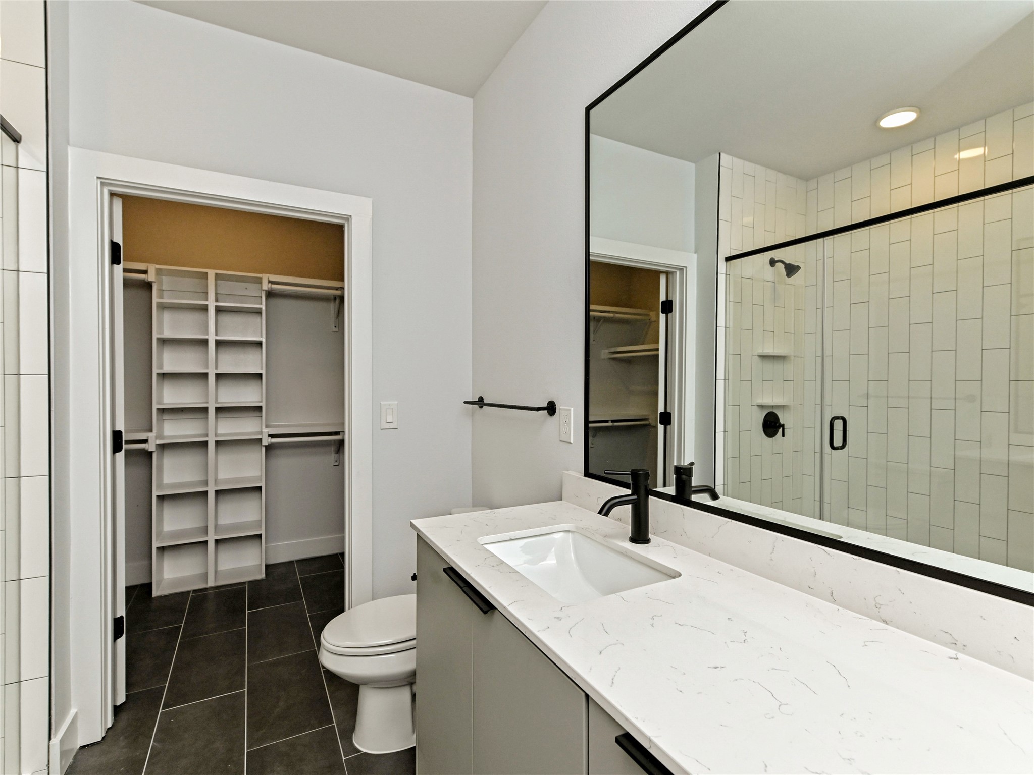 2500 Longview Street, Unit 518 Austin, TX 78705 - Photo 7 of 20 Bathroom with a spacious closet, tile patterned floors, vanity, a stall shower, and toilet