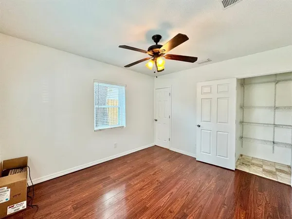 a view of a big room with wooden floor and windows