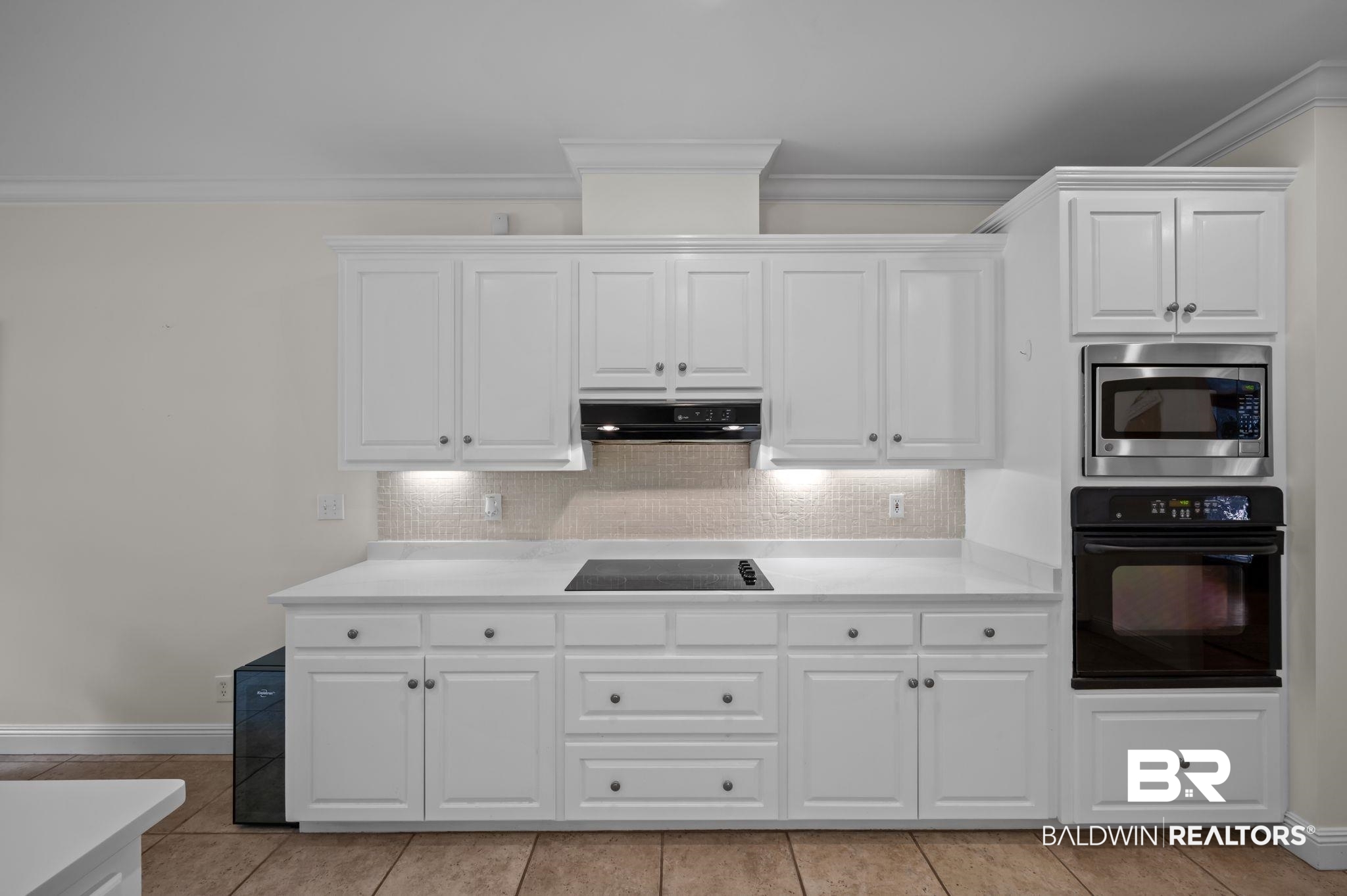 30151 Dolive Ridge Daphne, AL 36527 - Photo 10 of 37 Kitchen with extractor fan, light countertops, black appliances, ornamental molding, and white cabinetry