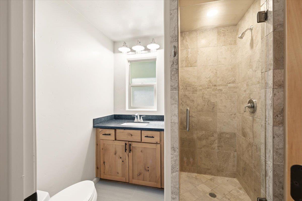 13630 Dry Creek Road Auburn, CA 95602 - Photo 46 of 46 a bathroom with a granite countertop sink a toilet and shower