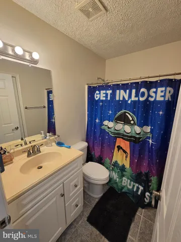 a bedroom with a bed and lamp with the dresser