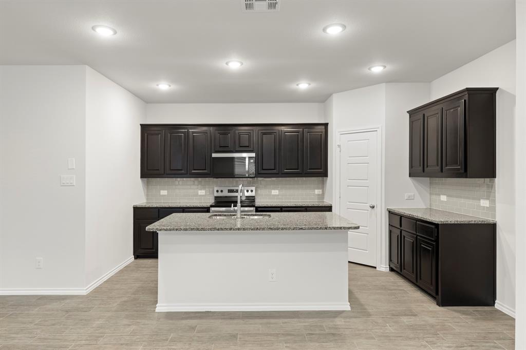 1708 Potomac Lane Blue Ridge, TX 75424 - Photo 4 of 27 a kitchen with stainless steel appliances granite countertop a sink and a stove top oven with wooden floor