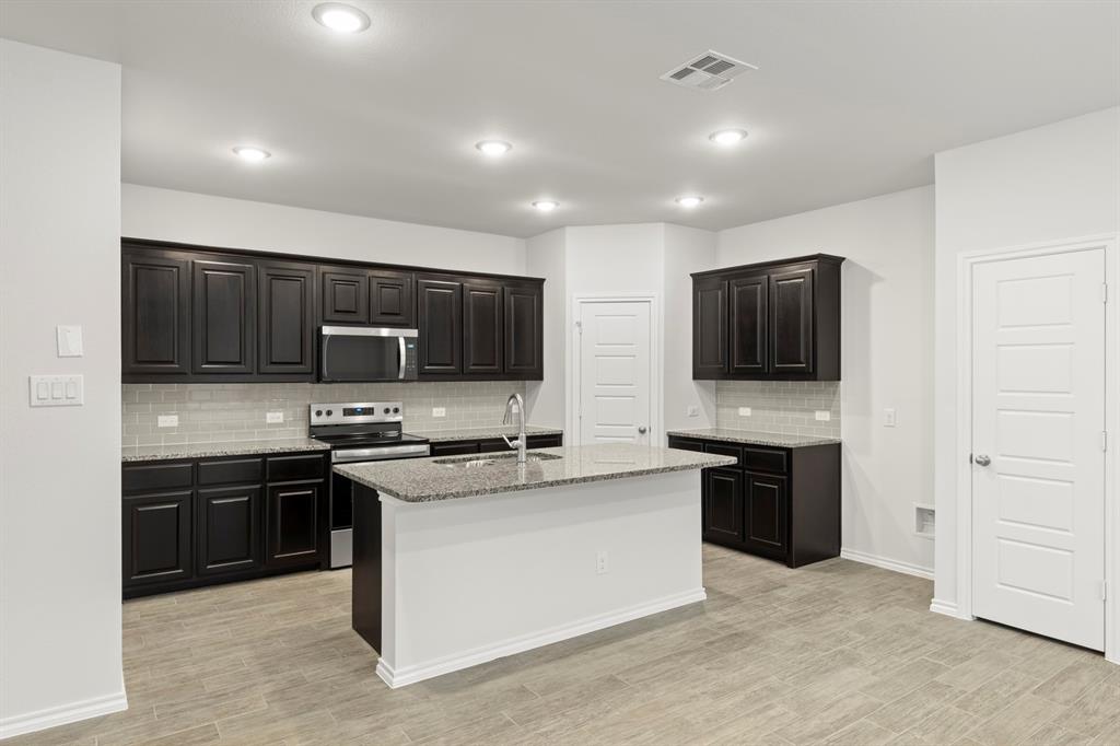 1708 Potomac Lane Blue Ridge, TX 75424 - Photo 6 of 27 a kitchen with stainless steel appliances granite countertop a stove top oven a sink dishwasher a refrigerator and a microwave
