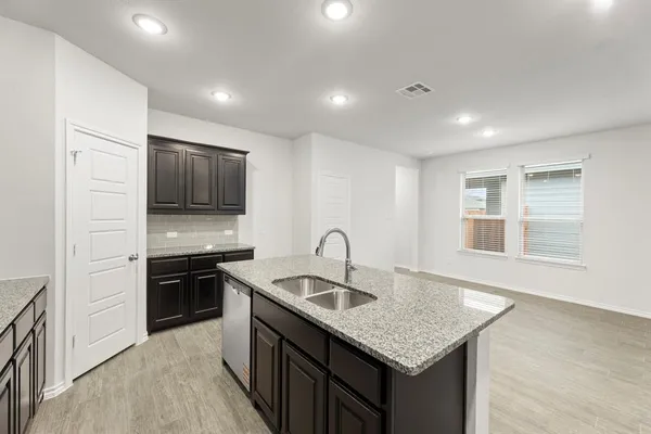 a kitchen with granite countertop kitchen island stainless steel appliances a sink stove and refrigerator