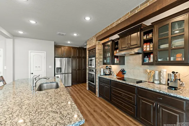 a kitchen with stainless steel appliances kitchen island granite countertop a refrigerator and a sink