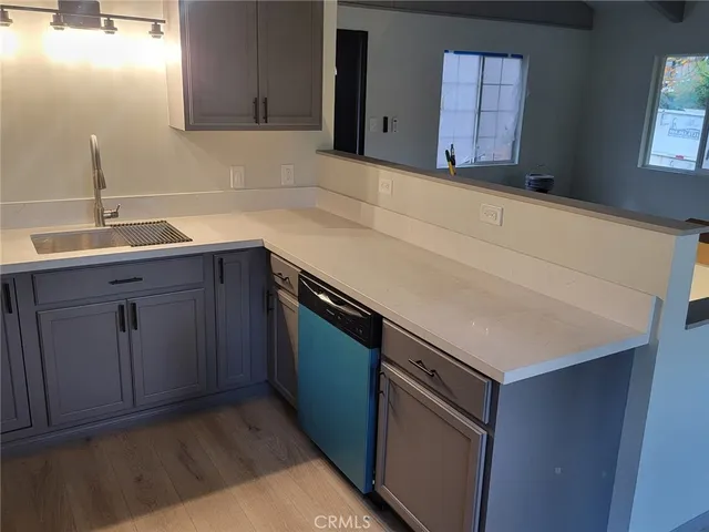 a kitchen with a sink cabinets and wooden floor