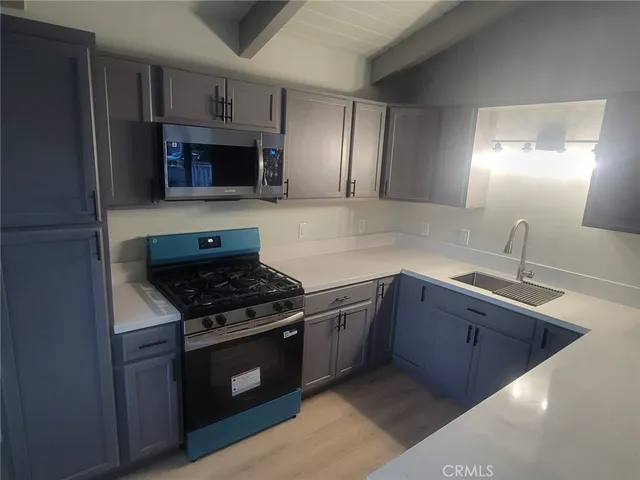a kitchen with stainless steel appliances granite countertop a sink stove and microwave