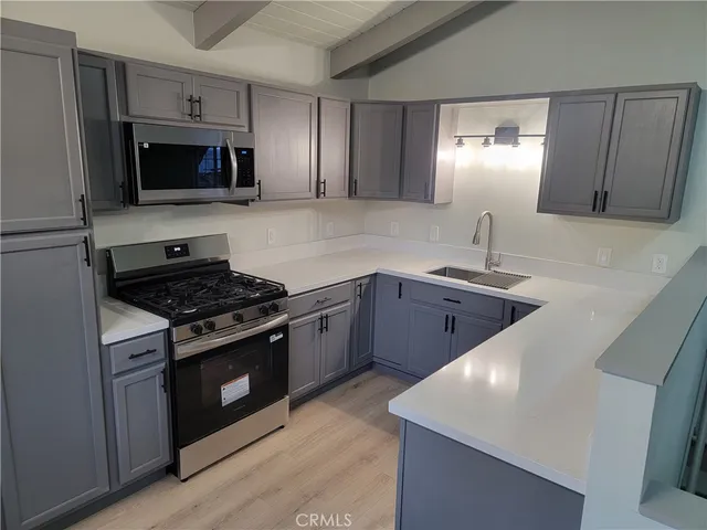 a kitchen with stainless steel appliances granite countertop a sink stove and microwave