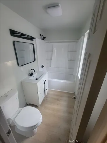 a white toilet sitting next to a bath tub