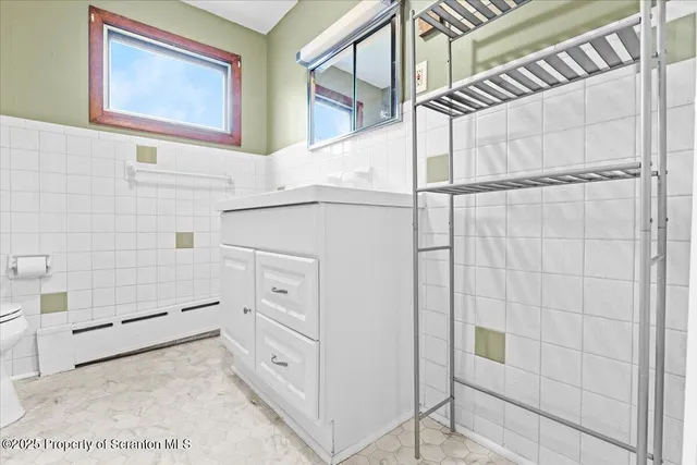 a white toilet sitting next to a shower