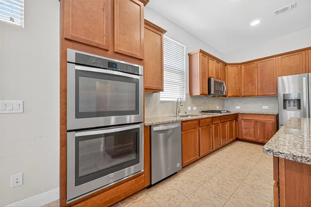 a kitchen with stainless steel appliances granite countertop a stove microwave and sink