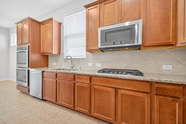 a kitchen with granite countertop cabinets stainless steel appliances and a sink