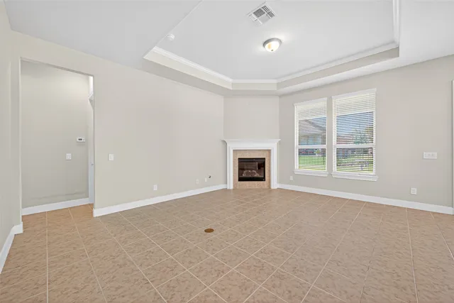 an empty room with windows and fireplace
