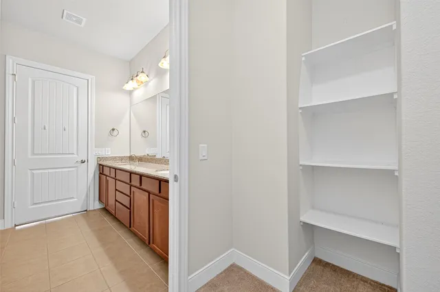 a spacious bathroom with a granite countertop sink and a mirror