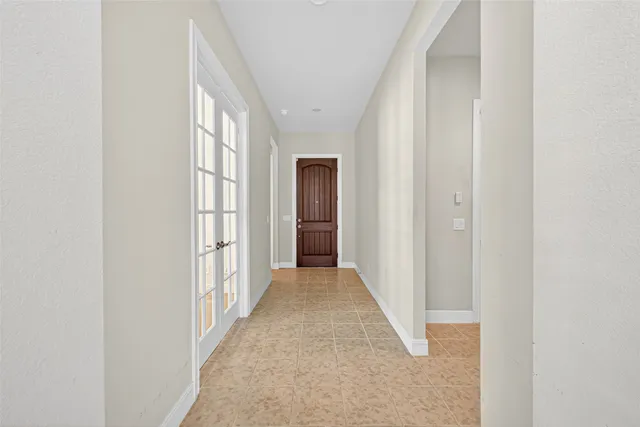 a view of a hallway with wooden floor and a bathroom