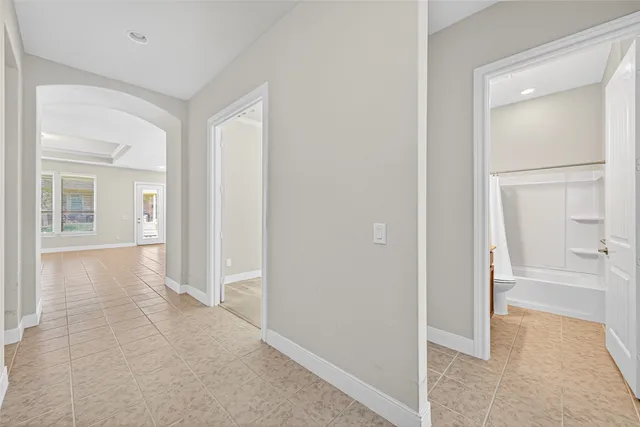 an empty room with a bathroom and mirror