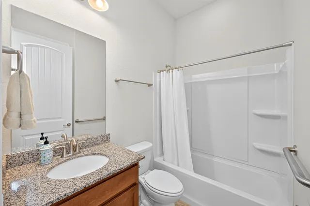 a bathroom with a granite countertop sink toilet and shower