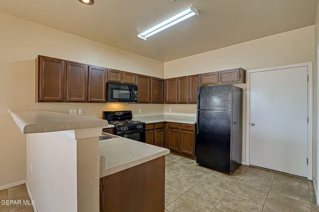 a bedroom with a bed and a refrigerator