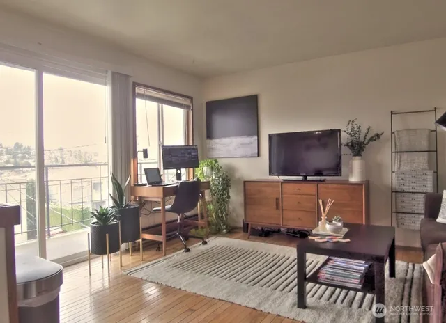 a living room with furniture a flat screen tv and a large window