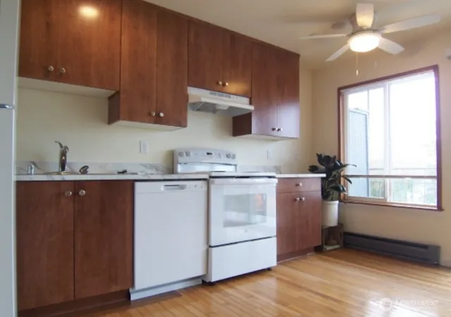 a kitchen with granite countertop wooden cabinets and white appliances