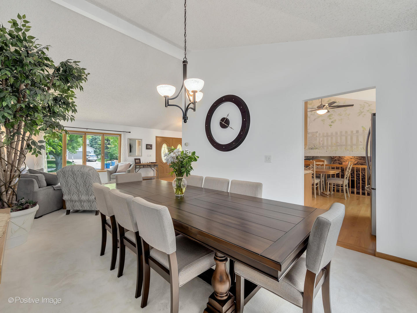 516 Camdon Circle Bartlett, IL 60103 - Photo 4 of 34 a view of a dining room and a livingroom with furniture wooden floor a rug a potted plant and a chandelier