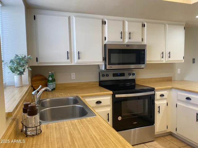 a large kitchen with kitchen island a stove a sink dishwasher and a refrigerator with wooden floor