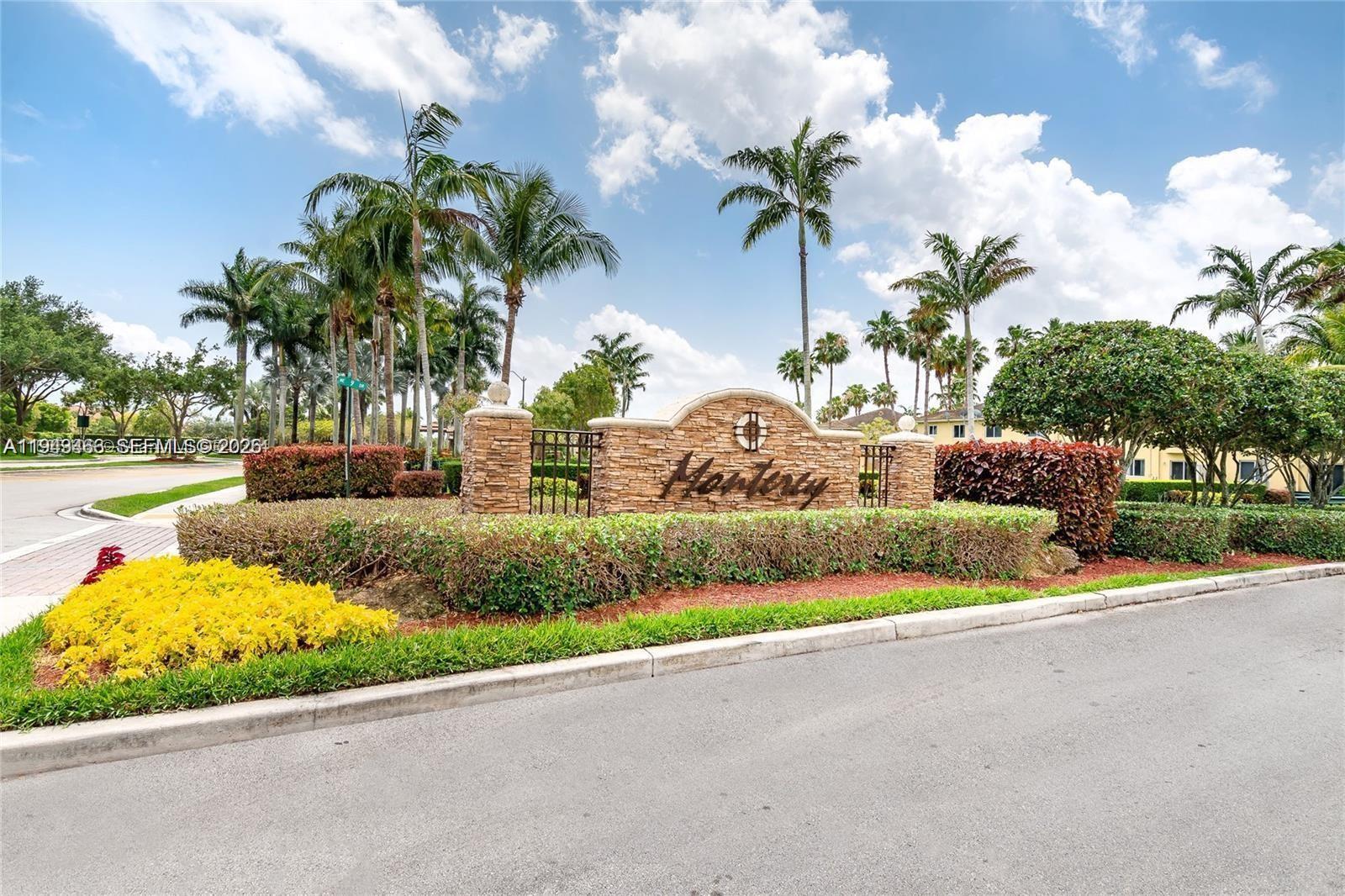 a front view of a house with a garden and lake view
