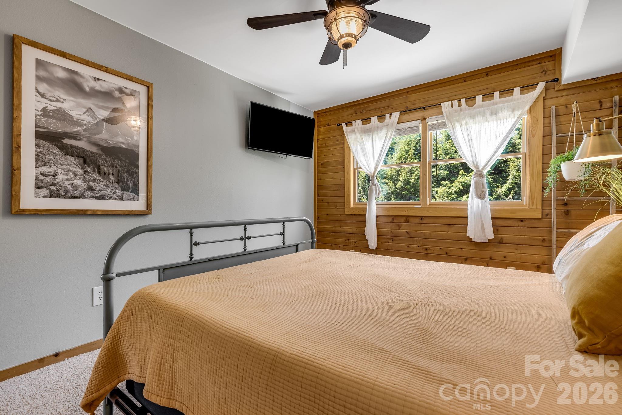 694 Boulder Road Marshall, NC 28753 - Photo 17 of 44 a bedroom with a large bed and a flat tv screen
