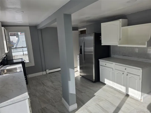 a kitchen with a refrigerator sink and cabinets