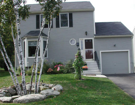 39 Country Side Road, Unit 39 Bellingham, MA 02019 - Photo 1 of 2 a front view of a house with a garden and plants