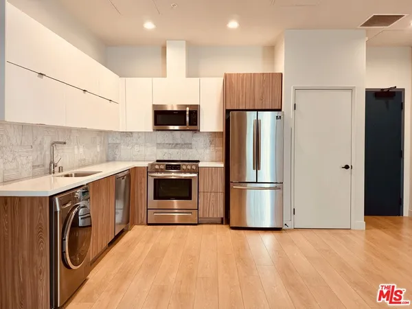 a kitchen with stainless steel appliances a refrigerator sink and cabinets