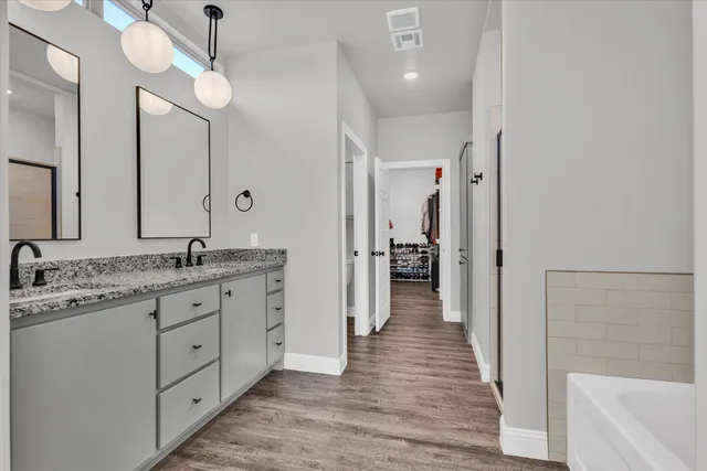 a bathroom with a granite countertop sink a mirror and shower