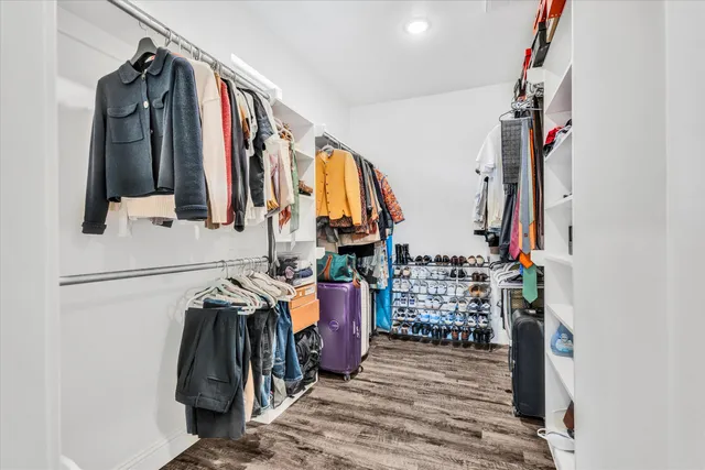a view of walk in closet with clothes and shoes