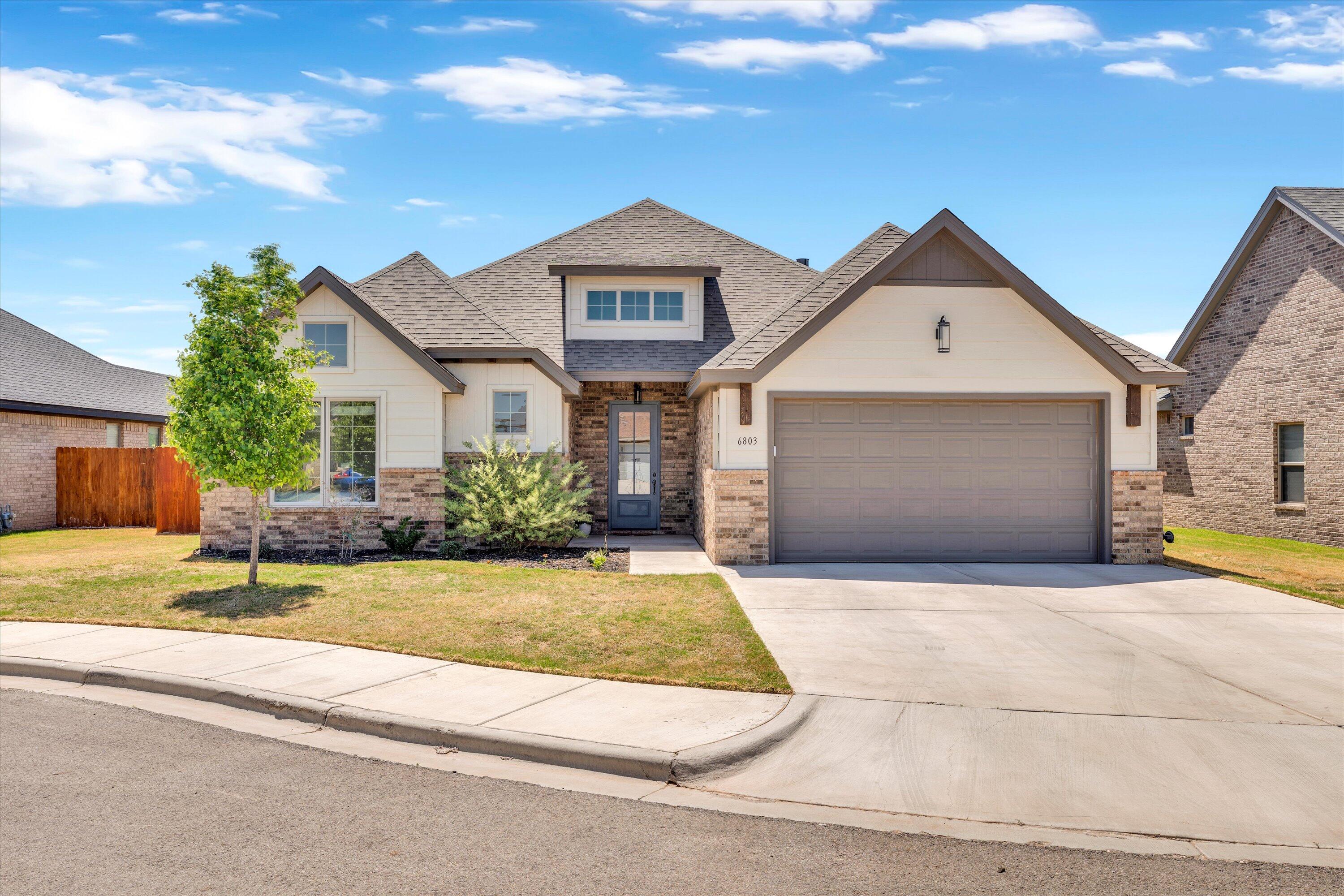 6803 52nd Street Lubbock, TX 79407 - Photo 28 of 34 a front view of a house with a yard and garage